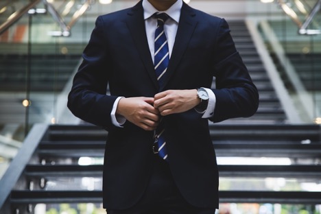 A man in a suit adjusting his jacket, symbolizing professionalism and legal expertise.