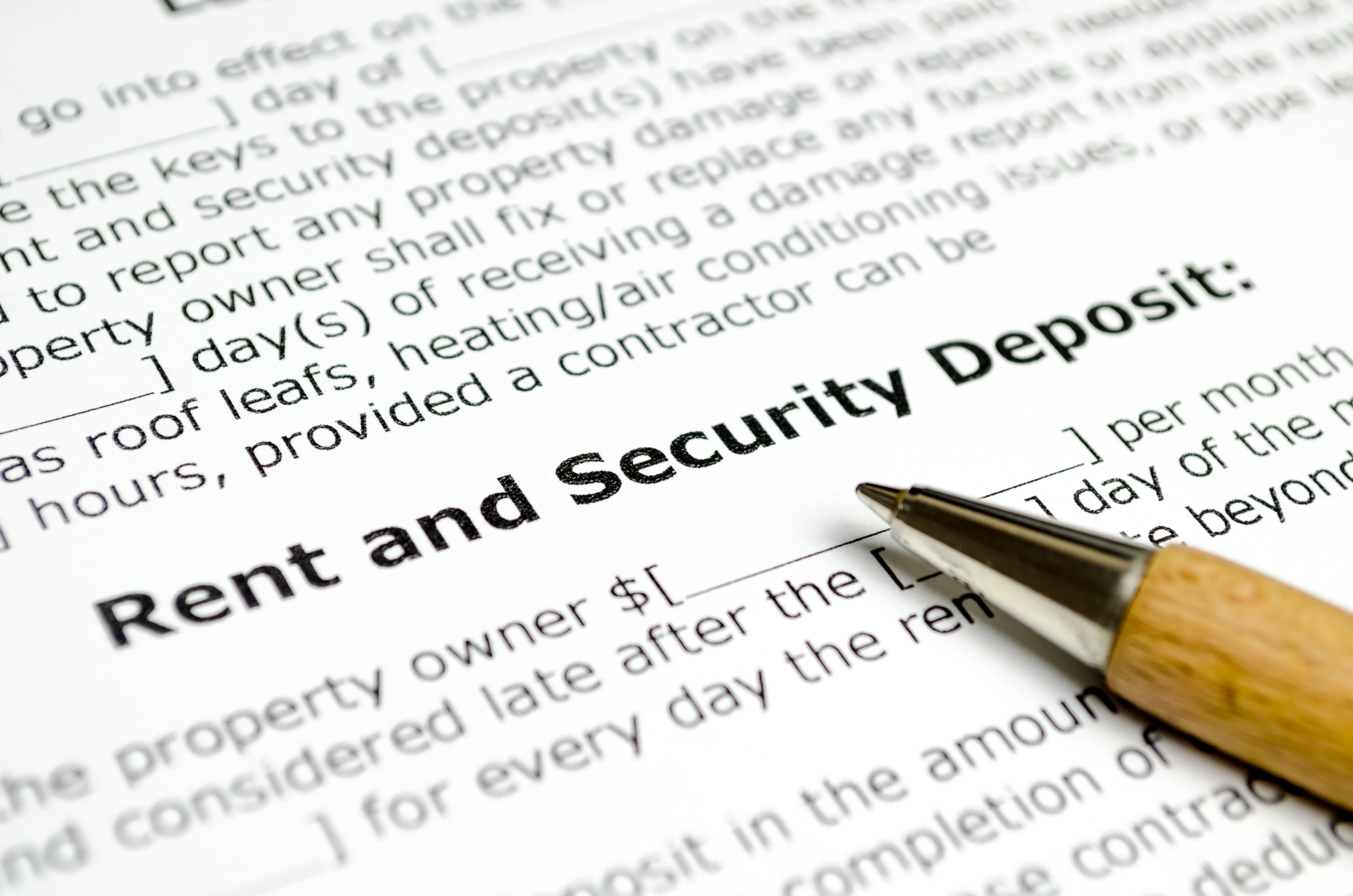 A security deposit clause in a lease agreement with a pen resting on the document, emphasizing financial terms of rental contracts.