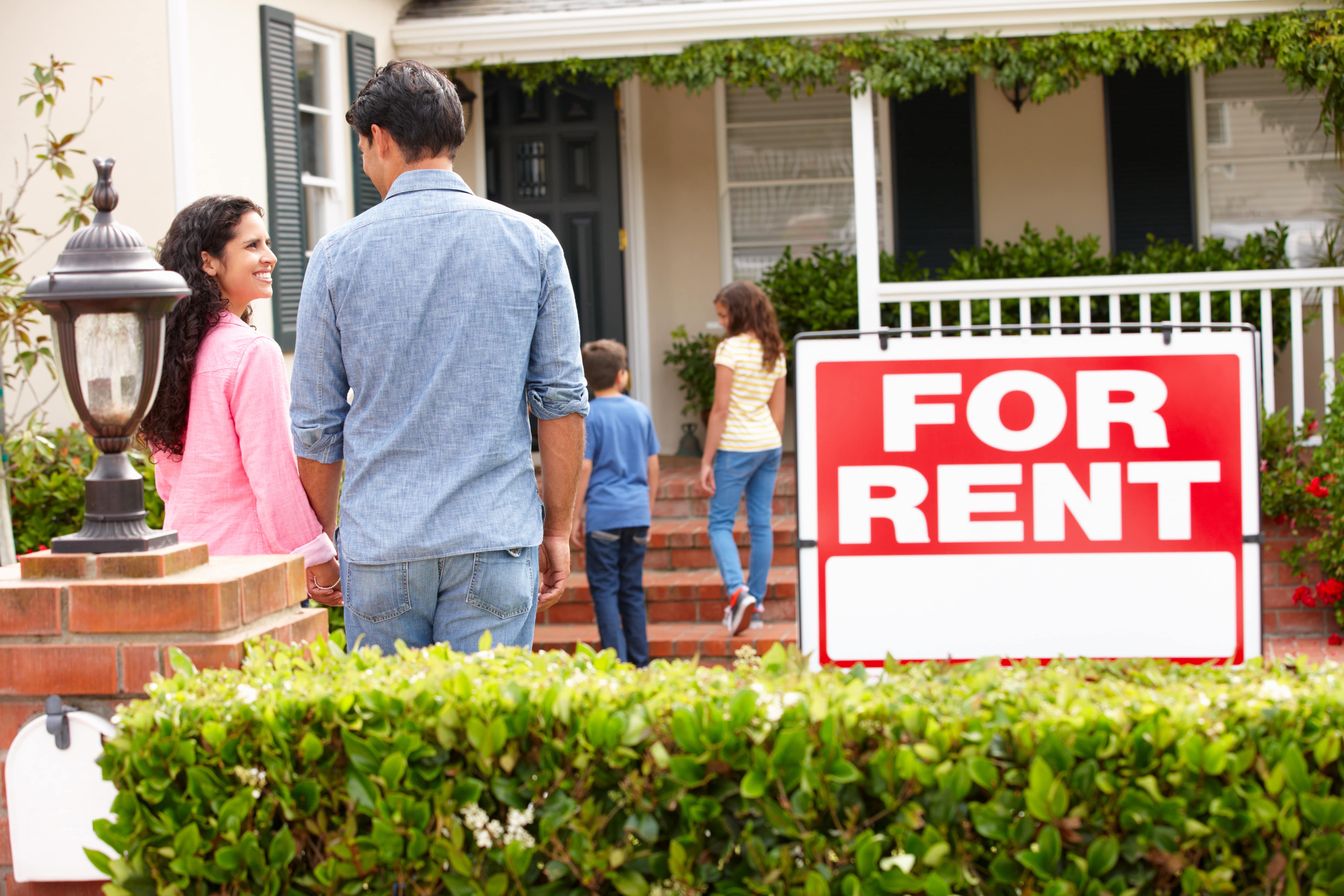 Family viewing a rental home with a ‘For Rent’ sign in Central Florida.