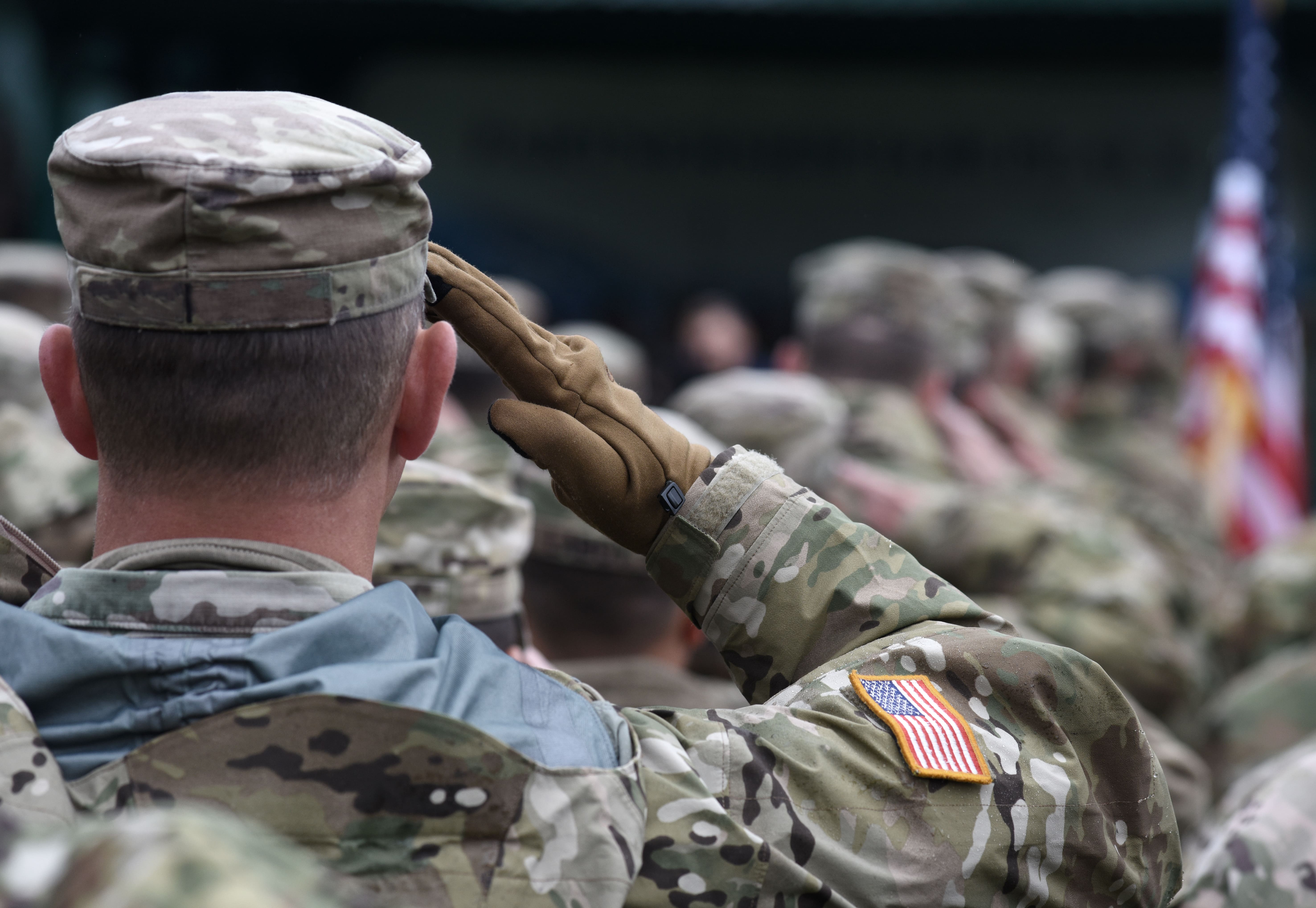 Military personnel saluting in uniform, representing lease-breaking rights under the Servicemembers Civil Relief Act (SCRA) for military deployment.