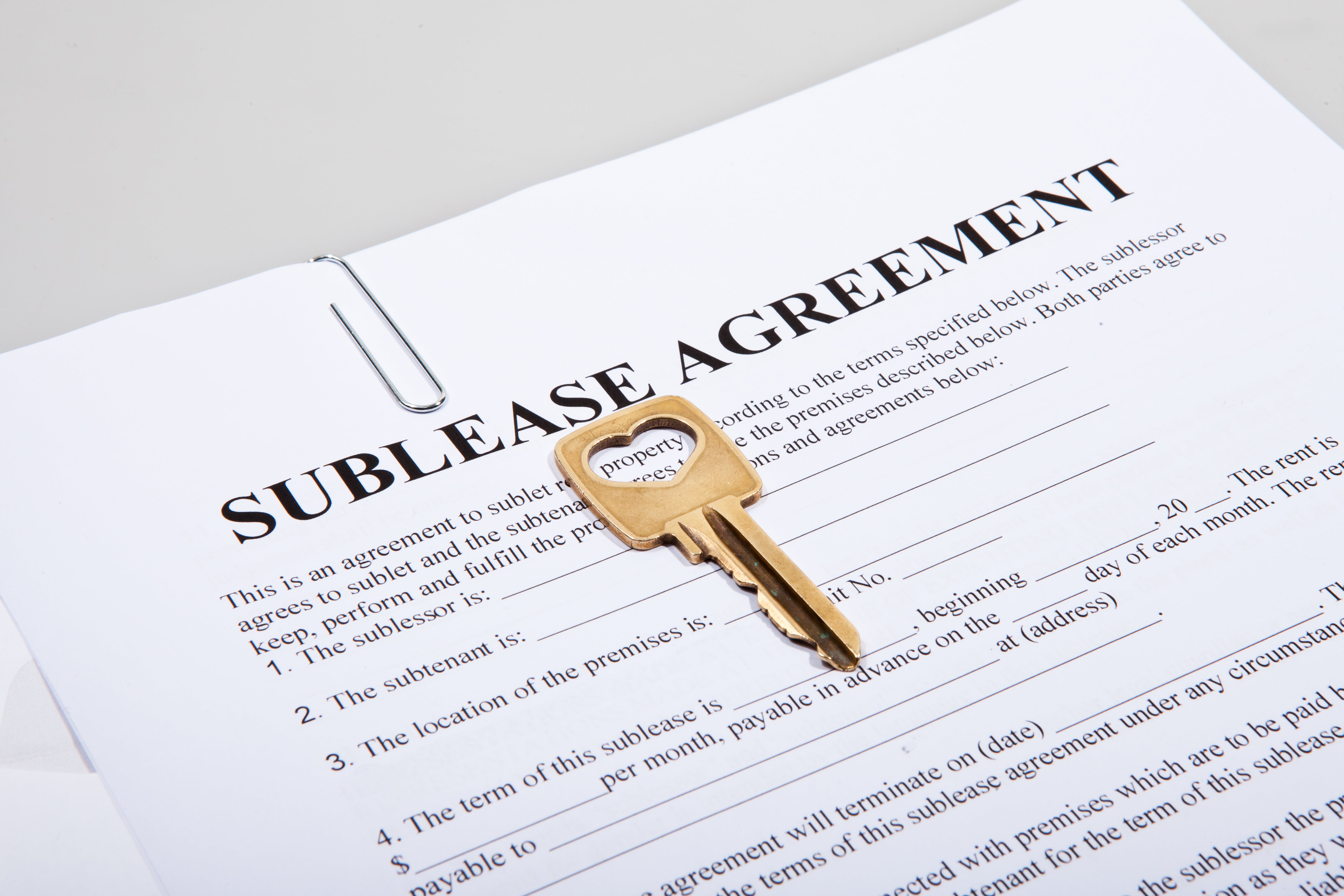 A sublease agreement with a key on top, representing subletting as an alternative to breaking a lease.