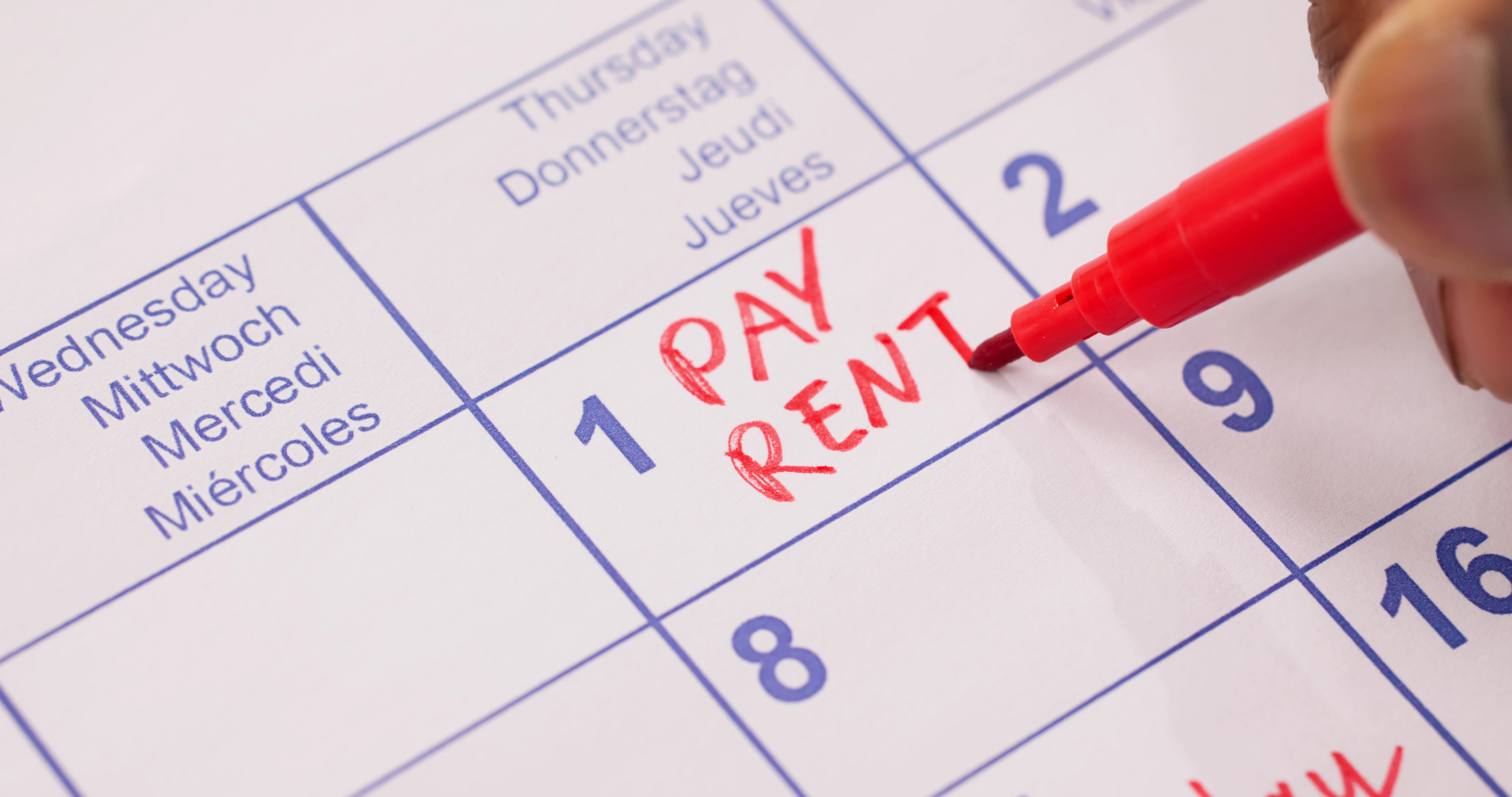 A calendar with 'PAY RENT' written on the first day of the month.