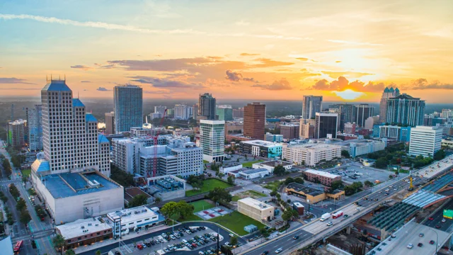 Central Florida investment opportunities — Orlando skyline at sunset with high-rise buildings and growing urban development.