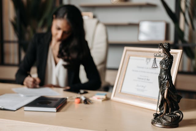 professional-working-at-a-desk-and-lady-justice-statue-in-the-foreground