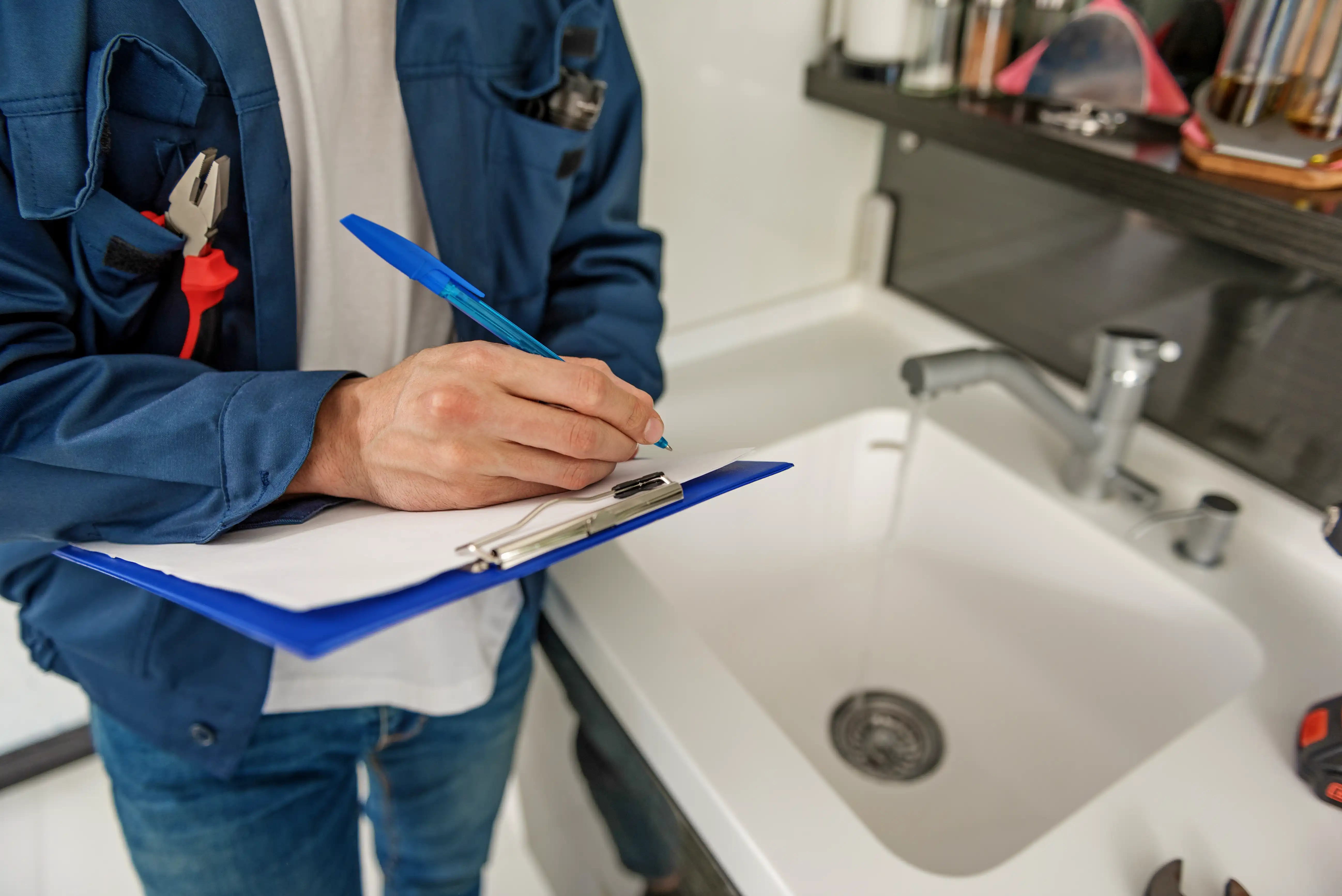 Property manager performing a rental inspection and documenting sink plumbing condition on a checklist.